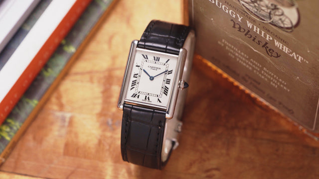 Classic mens Cartier dress watch sitting upright on table